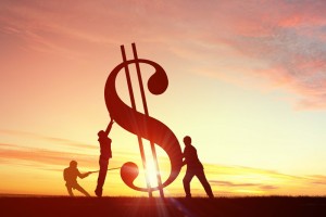 Greenback symbol as a statue being held up at sunrise.