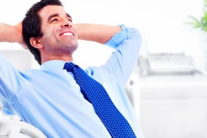 Smiling handsome businessman relaxing in a modern office.